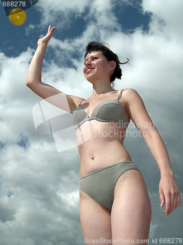 Image of Girl in bikini throwin ball