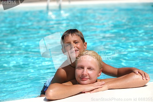 Image of happy boy and mom in the swimming pool