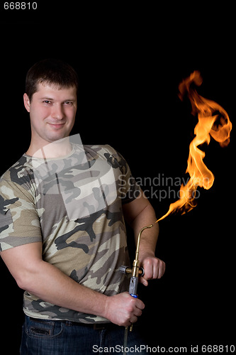 Image of Strong young man with a gas torch