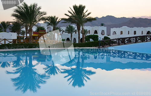 Image of Palms reflection in pool at tropical sunset