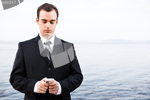 Image of Caucasian businessman texting 