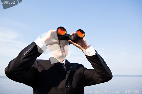 Image of Caucasian businessman with binoculars