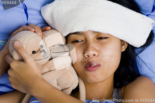 Image of pretty young woman sick in bed