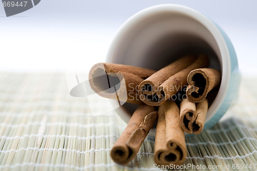 Image of Cinnamon sticks in a blue cup.