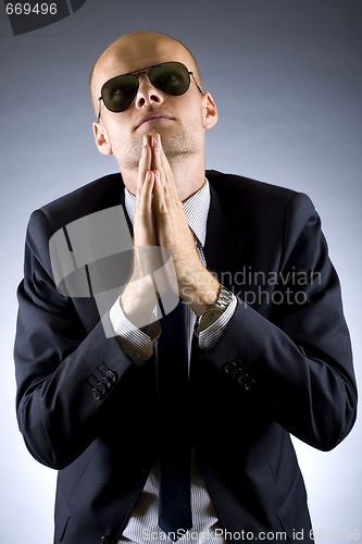 Image of portrait of businessman praying for success