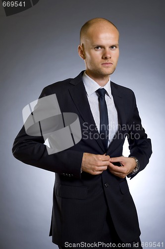 Image of businessman buttoning his coat