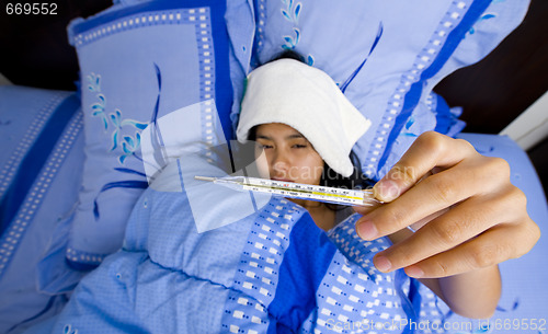 Image of pretty young woman sick in bed