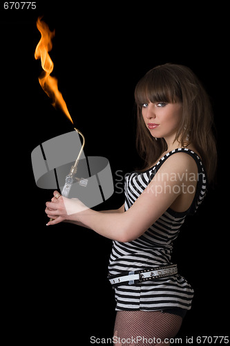 Image of Pretty young woman with a gas torch. Isolated