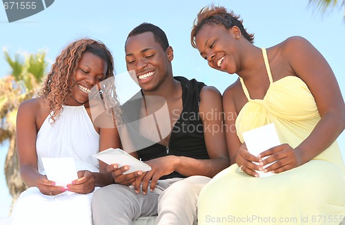 Image of Happy Siblings Looking at Photographs