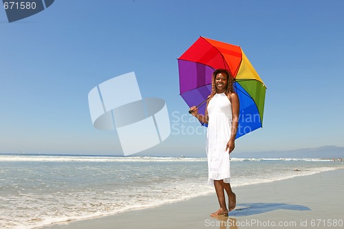 Image of African American Woman At The Beach Holding an Umbrella