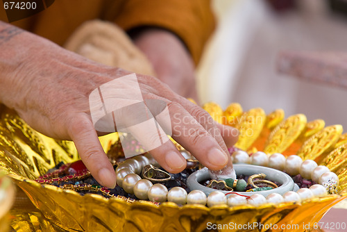 Image of Hand of Buddhist monk painting religious symbols