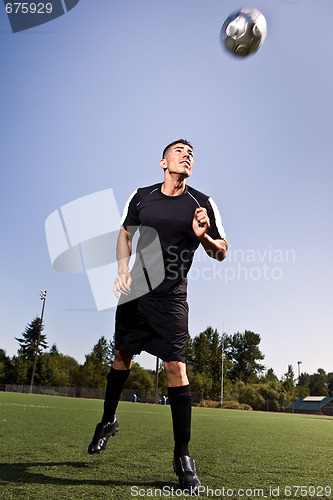 Image of Hispanic soccer or football player heading a ball
