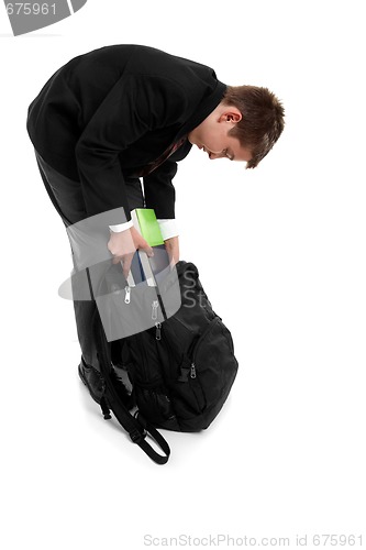 Image of School boy packing school bag