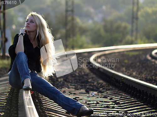 Image of Young woman sitting on rail