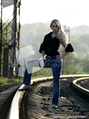 Image of Young woman staying on railway