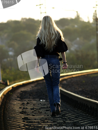 Image of Young woman walking by railway