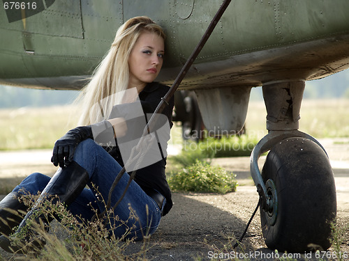 Image of Young woman sitting near airplane