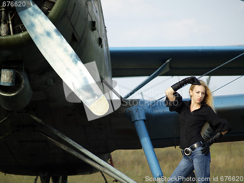 Image of Young woman near vintage airplane