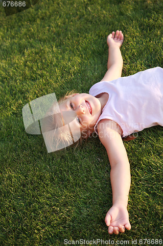 Image of Happy girl relaxing on a grass