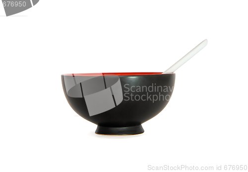 Image of Black Japanese bowl with white spoon side view isolated