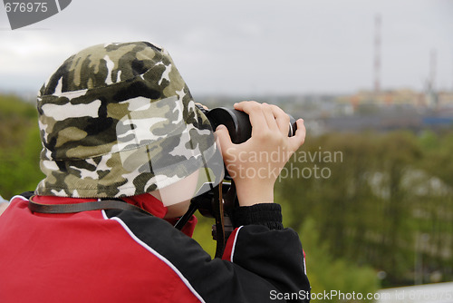 Image of boy observing nature through binoculars