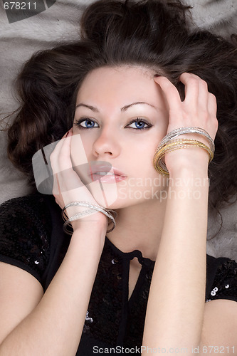 Image of Portrait of the beautiful girl lying on grey fur
