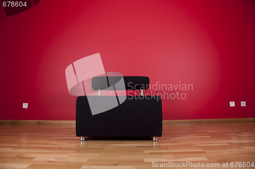 Image of couch next a red wall