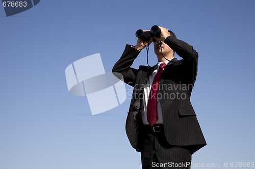 Image of Businessman looking through binoculars