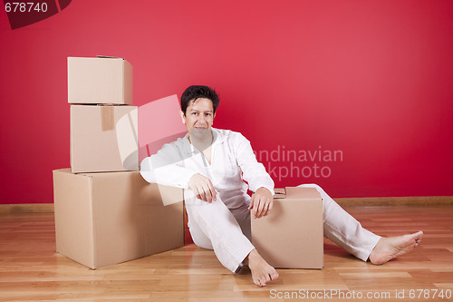 Image of Young men resting next to cardboard boxes