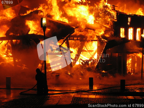 Image of Firefighter fighting burning hous