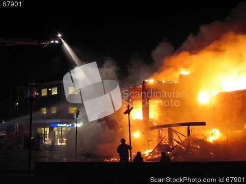 Image of Firefighter fighting burning house