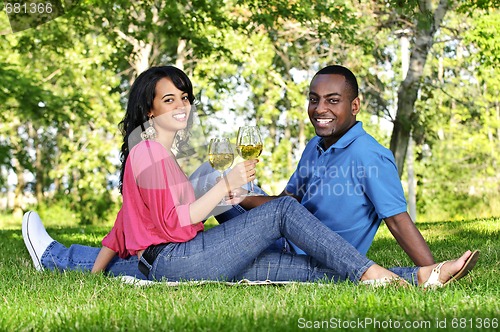 Image of Happy couple having wine in park