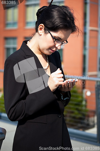 Image of Hispanic businesswoman texting 