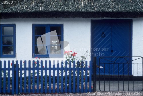 Image of Small house with blue windows and blue rails