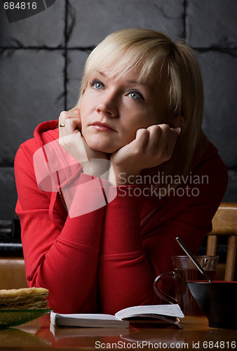 Image of thoughtful girl is in a cafe