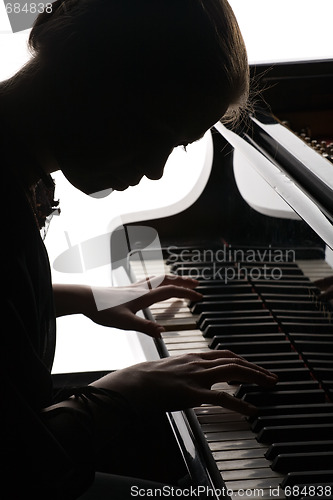 Image of beautiful girl playing the piano