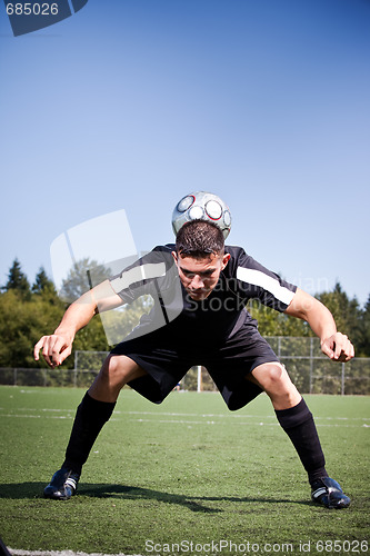 Image of Hispanic soccer or football player kicking a ball