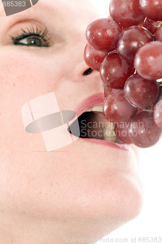Image of  woman eating fresh red grapes