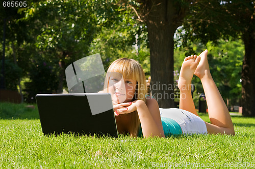 Image of Young girl on the grass with notebook