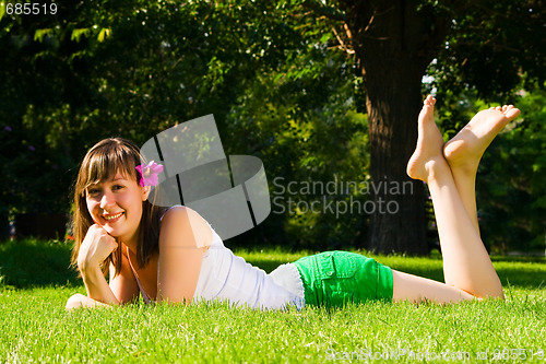 Image of Young smiling girl lies on grass