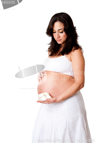Image of Pregnant woman holding baby shoes