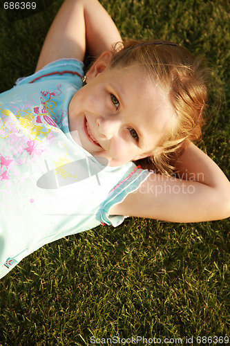 Image of Happy girl relaxing on a grass