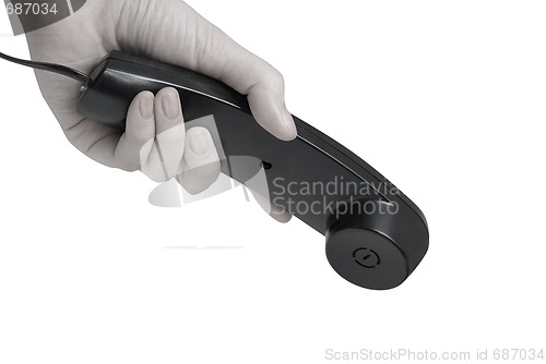 Image of office black telephone with hand dialing. 