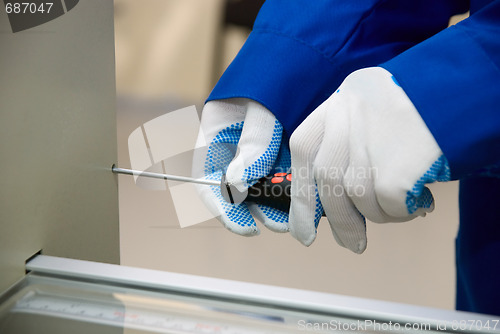 Image of A screwdriver in glove hand