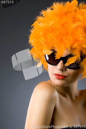 Image of pretty woman wearing an orange feather wig and sunglasses