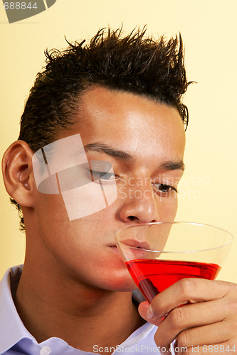 Image of Young man drinking red cocktail