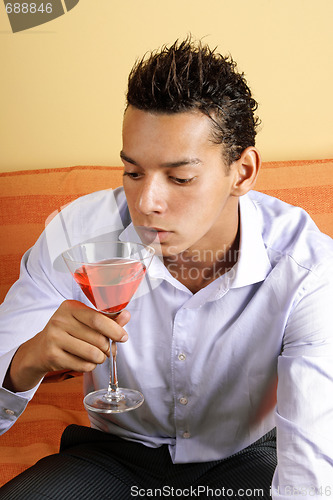 Image of Young man drinking red cocktail