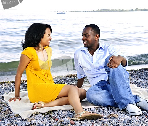 Image of Happy couple sitting at beach