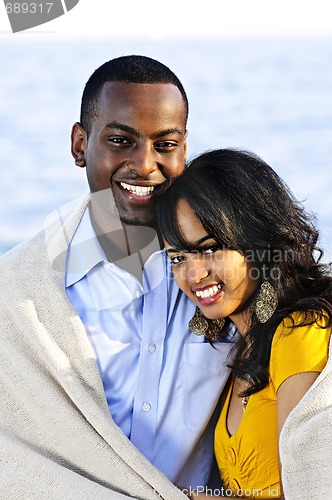 Image of Happy couple sharing blanket