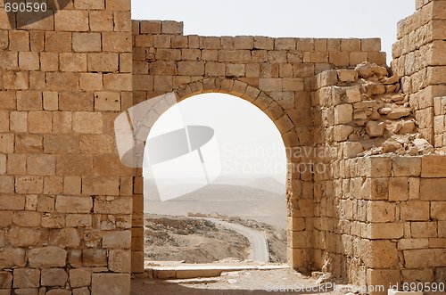 Image of Ancient stone arch and wall with desert view during sandstorm